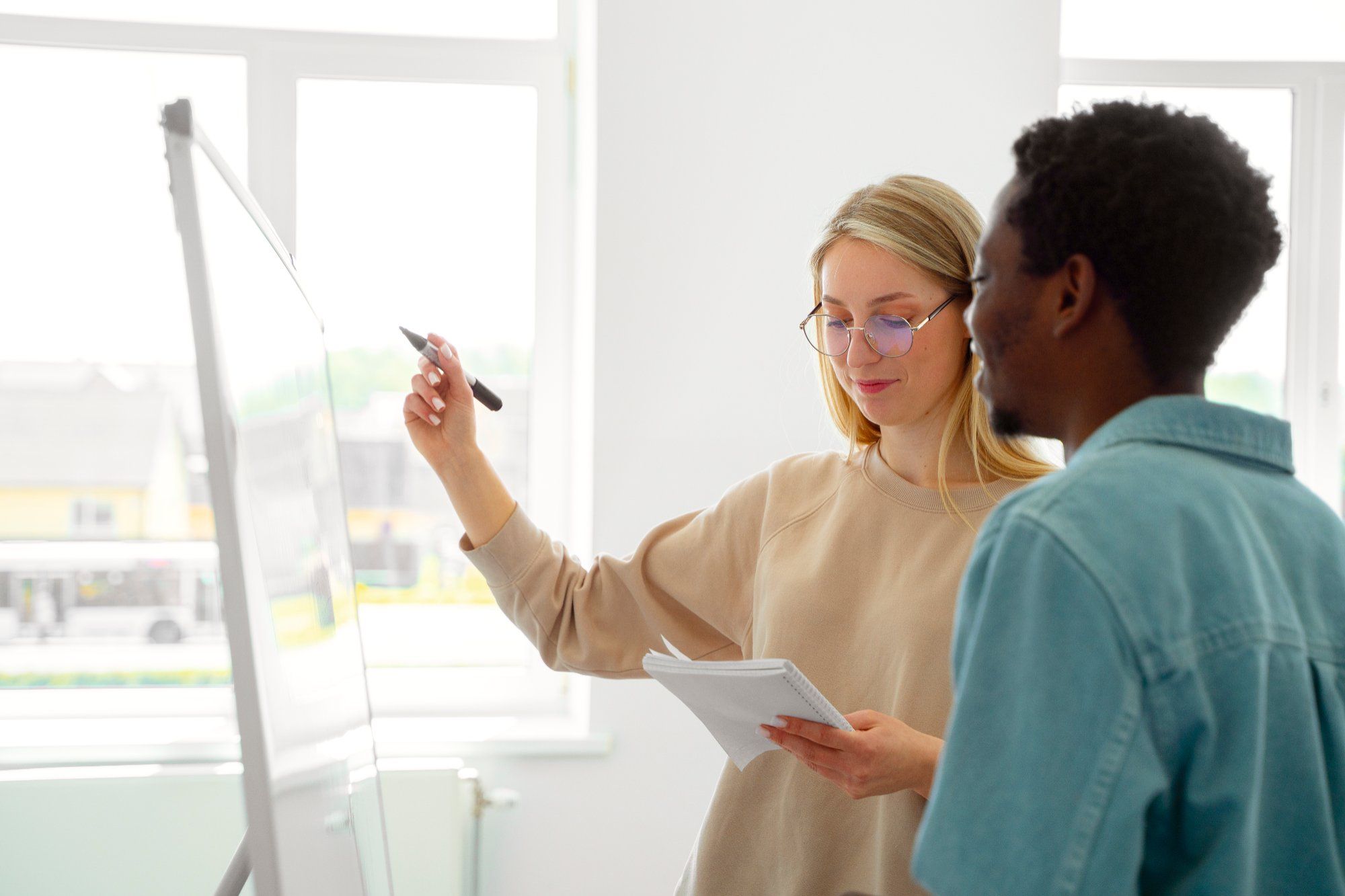 Zwei Kolleg:innen stehen am Flipchart und besprechen gemeinsam Werte im Arbeitsalltag
